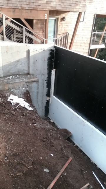 waterproofing added to vertical concrete wall. Insulation shown at bottom of wall will extend to top